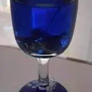 Vela de gel en bella copa de vidrio con caracoles y moños dorados en forma de adorno