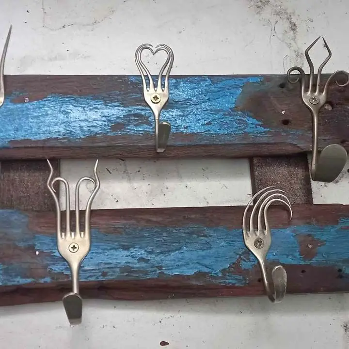 Perchero hecho de cubiertos de alpaca y madera recuperada hermoso