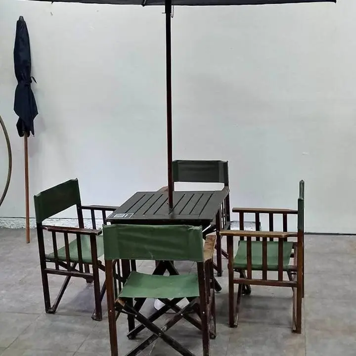 Mesa plegable de madera con cuatro sillas plegables y sombrilla
